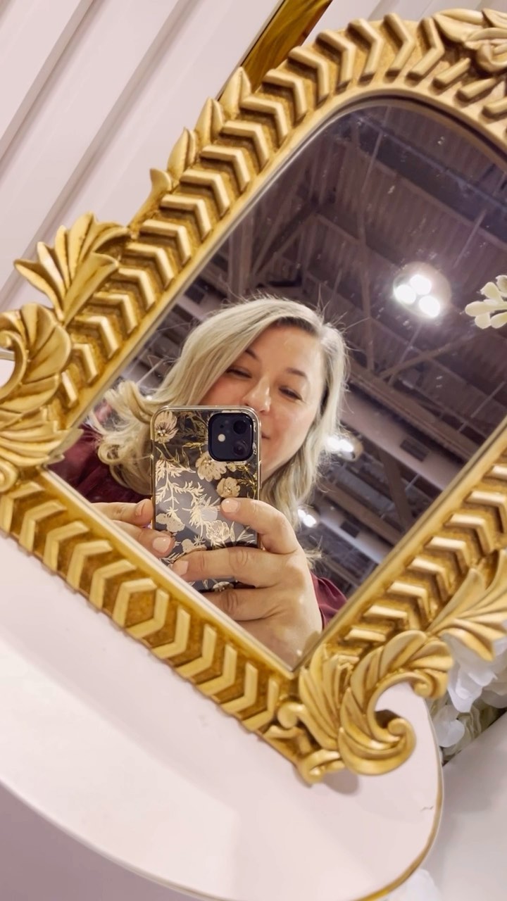 Image of a woman taking a picture in a mirror at the National Women’s Show in Toronto.
